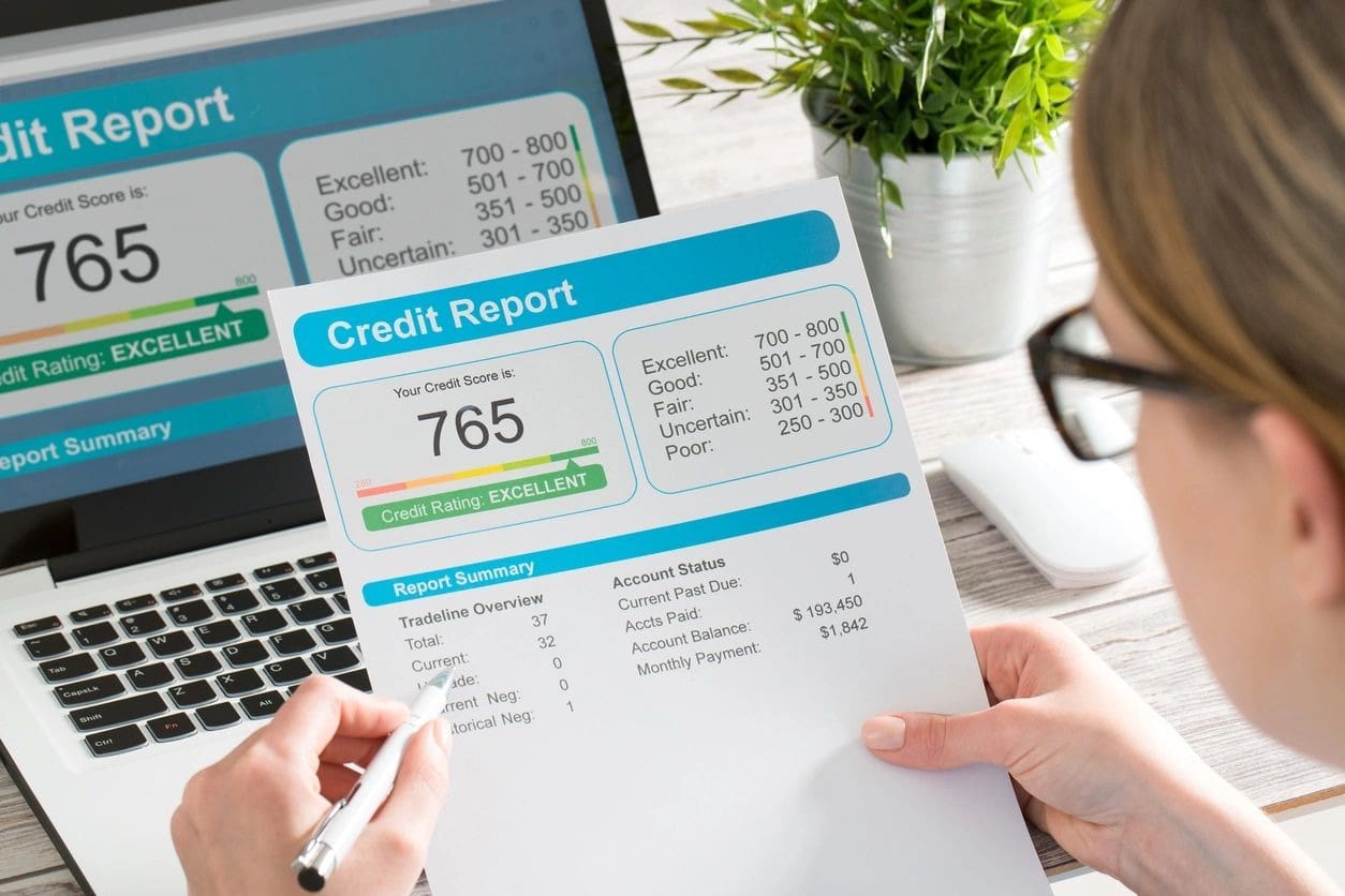 A person holding a paper with the words credit report on it.