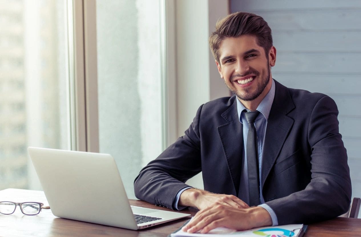 A man sitting at his desk with a laptop.